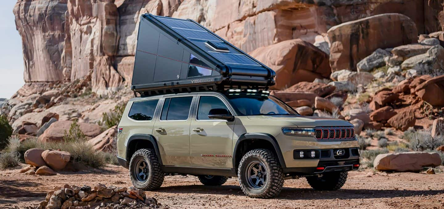 Display An angled passenger-side profile of the Wagoneer Overland Concept with its skyloft raised.