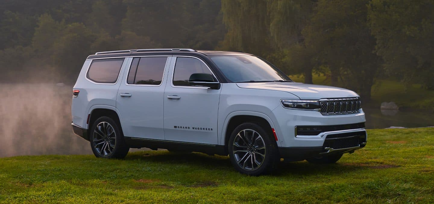 Display The 2023 Grand Wagoneer Series III parked off-road in a misty field.