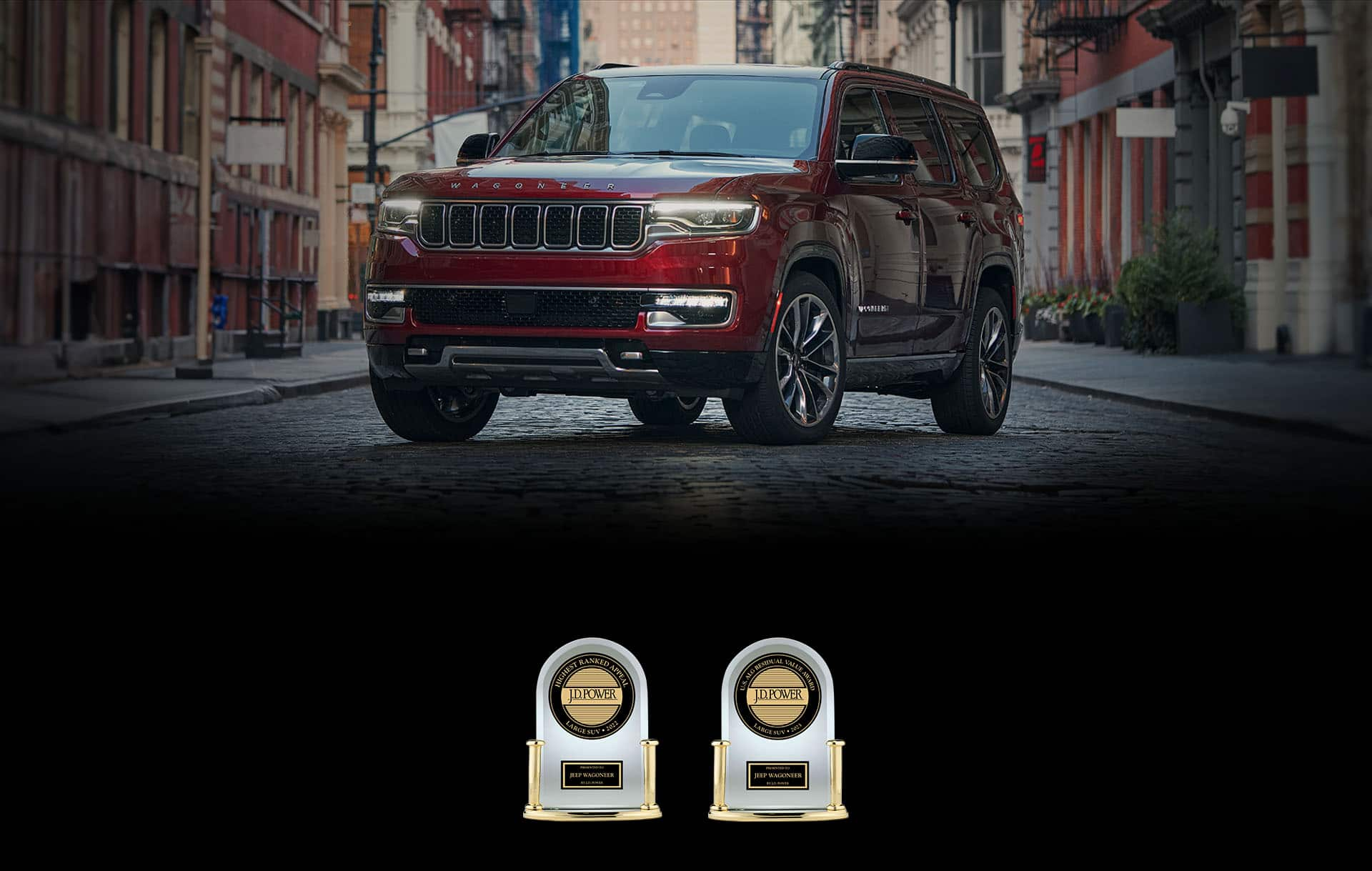 A red 2023 Wagoneer L Series III parked on a cobblestone street in a metropolitan neighborhood. Number 1 Driver Appeal among Large SUVs in 2022 and Number 1 in Residual Value Among Large SUVs in 2023.