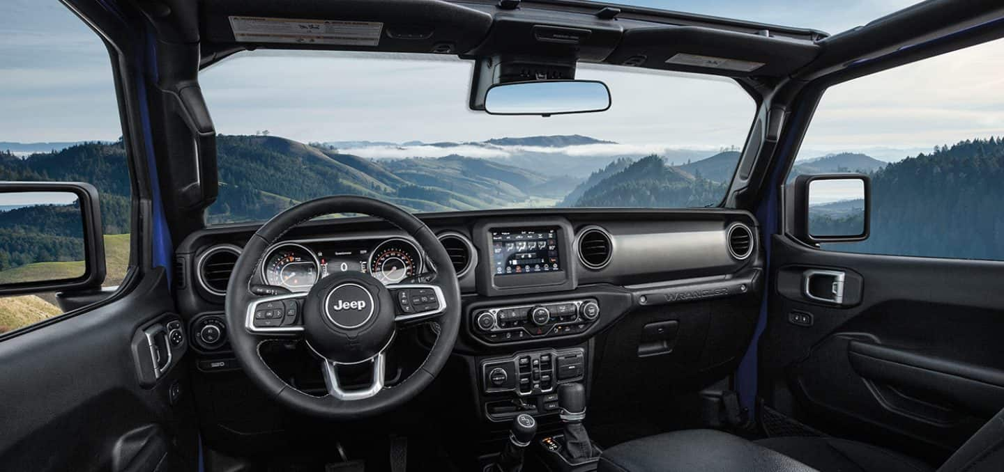 Display The interior of the 2023 Jeep Wrangler Overland with a view of the mountains visible outside.